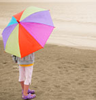 Girl with umbrella on winter beach